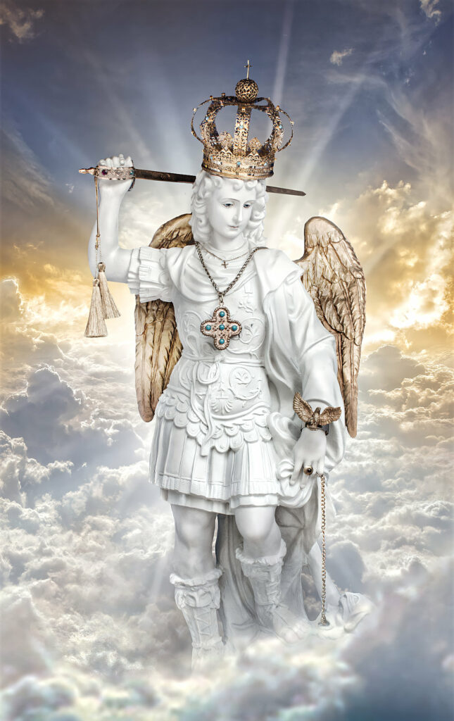 A statue of an angel holding a sword and wearing a crown, set against a cloudy sky